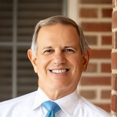 Dentist James Maragos Smiling In Front Of Brick Wall